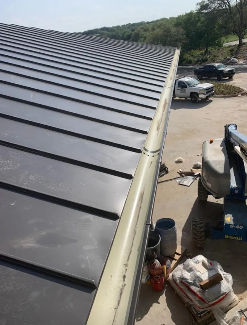 Standing seam panel and gutter detail on a metal roofing jobsite in Great Neck Plaza